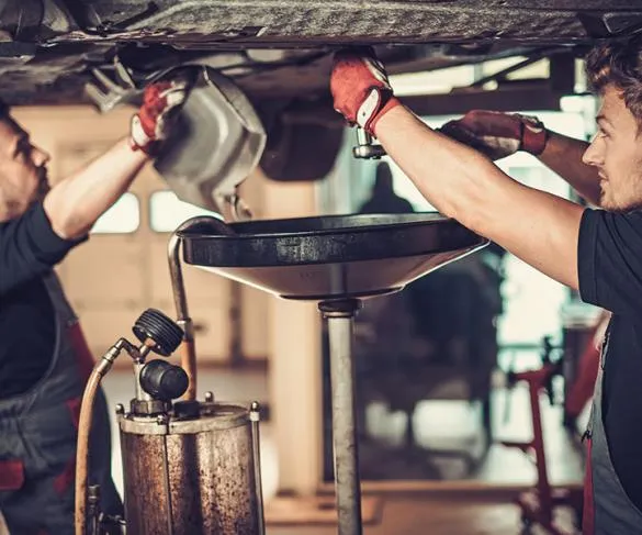 Mechanics repairing a car in a workshop