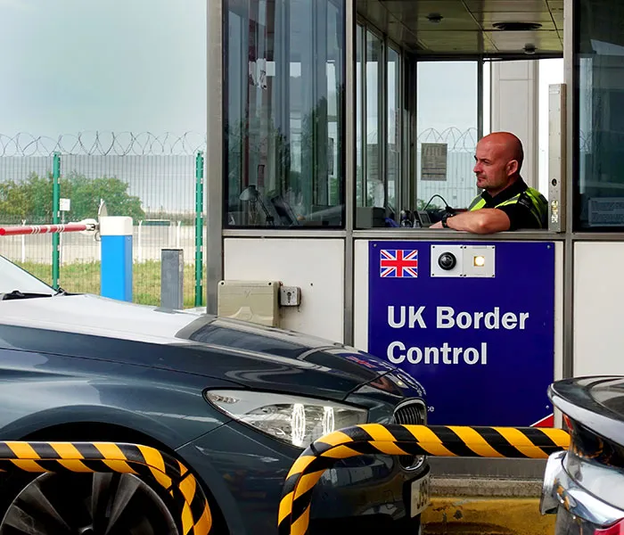 A border control officer is inside a booth with a 